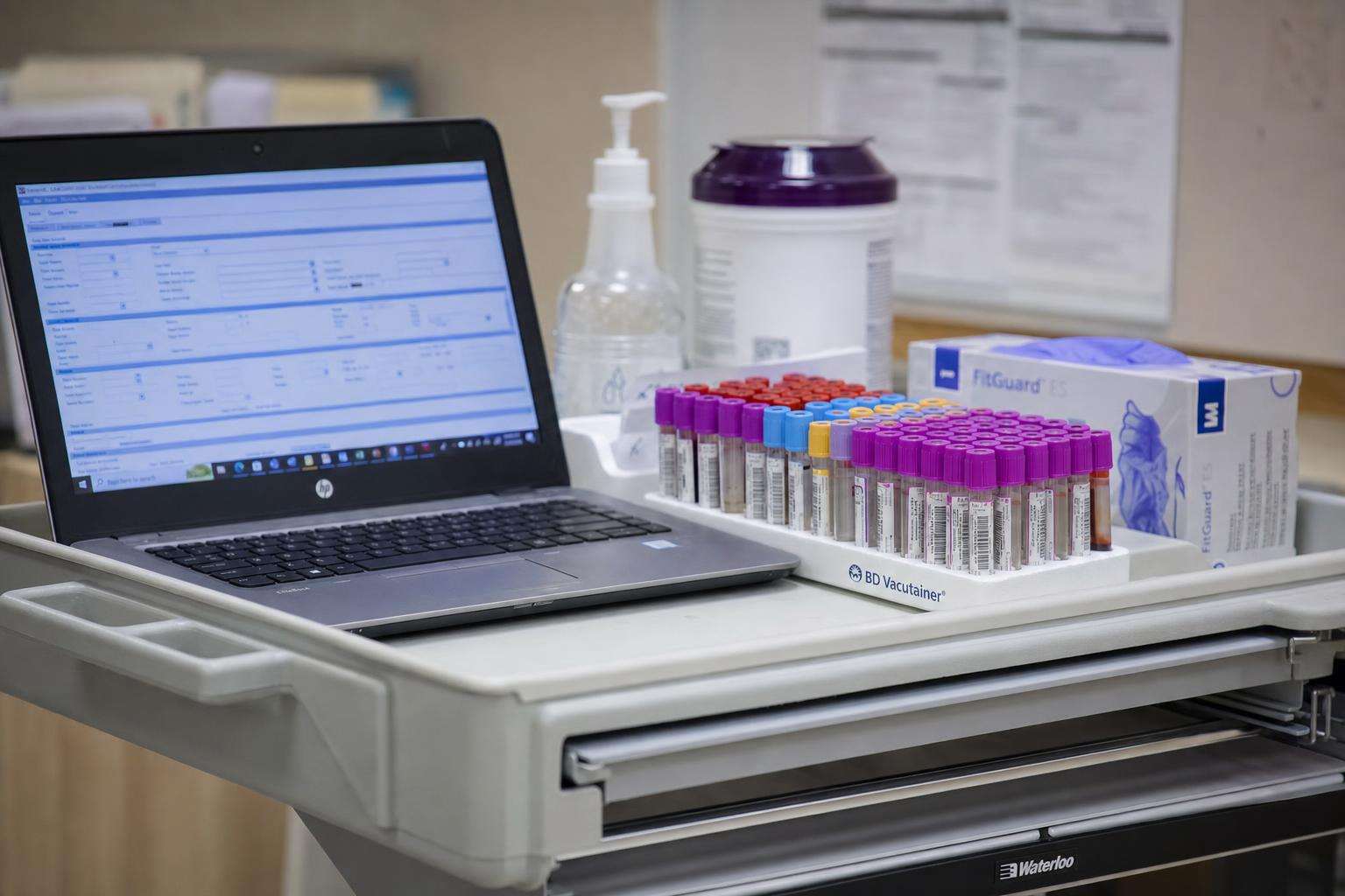 Lab requisition form and blood sample tubes on a clean clinical counter, no people