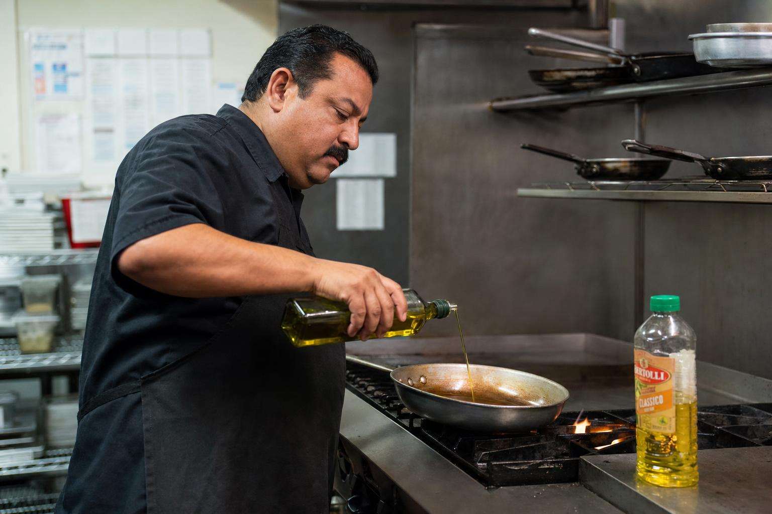 Bottles of cooking oils beside a skillet on a stove, no people
