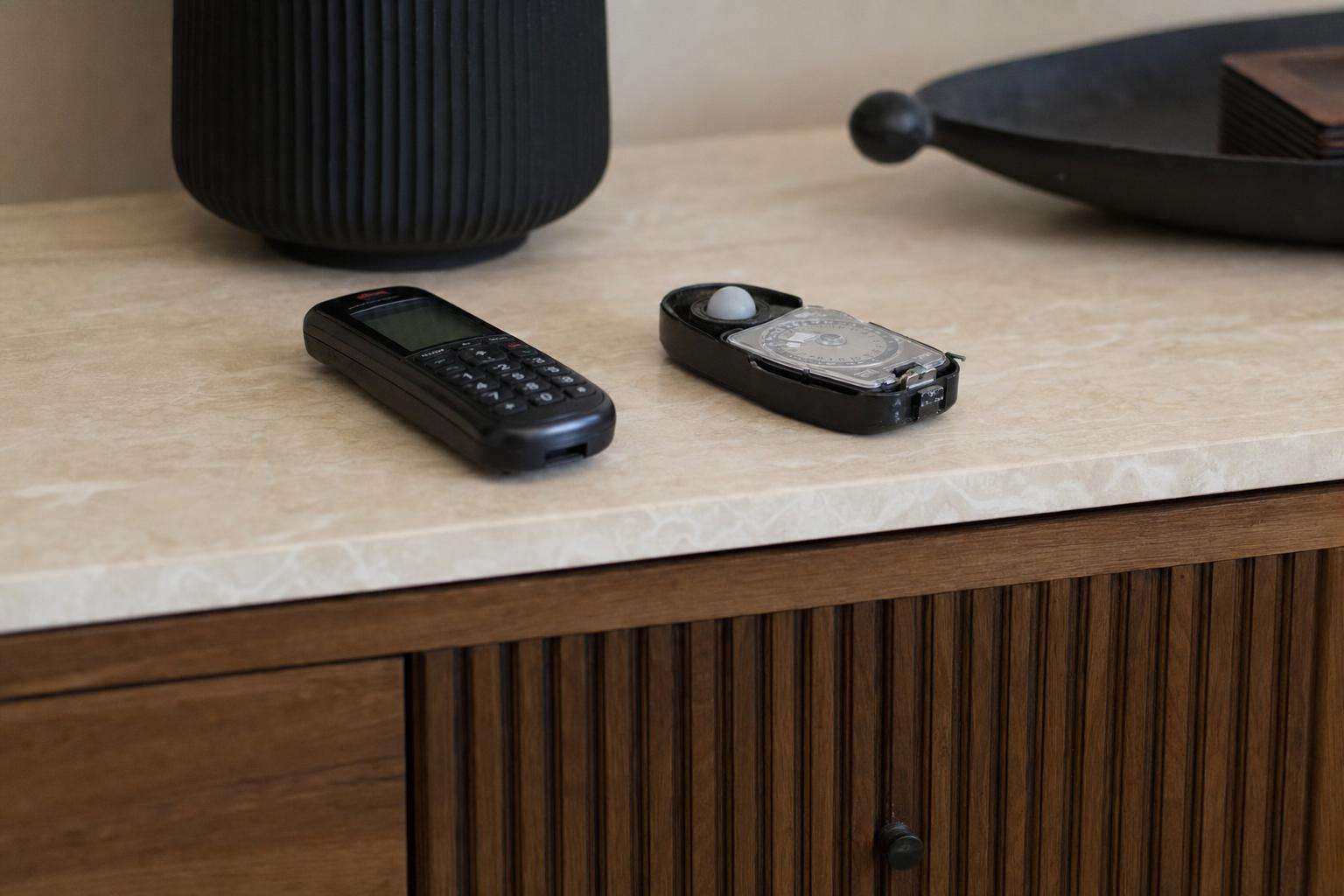 Home hallway with smartphone on table and simple magnetic field meter, soft light, no people