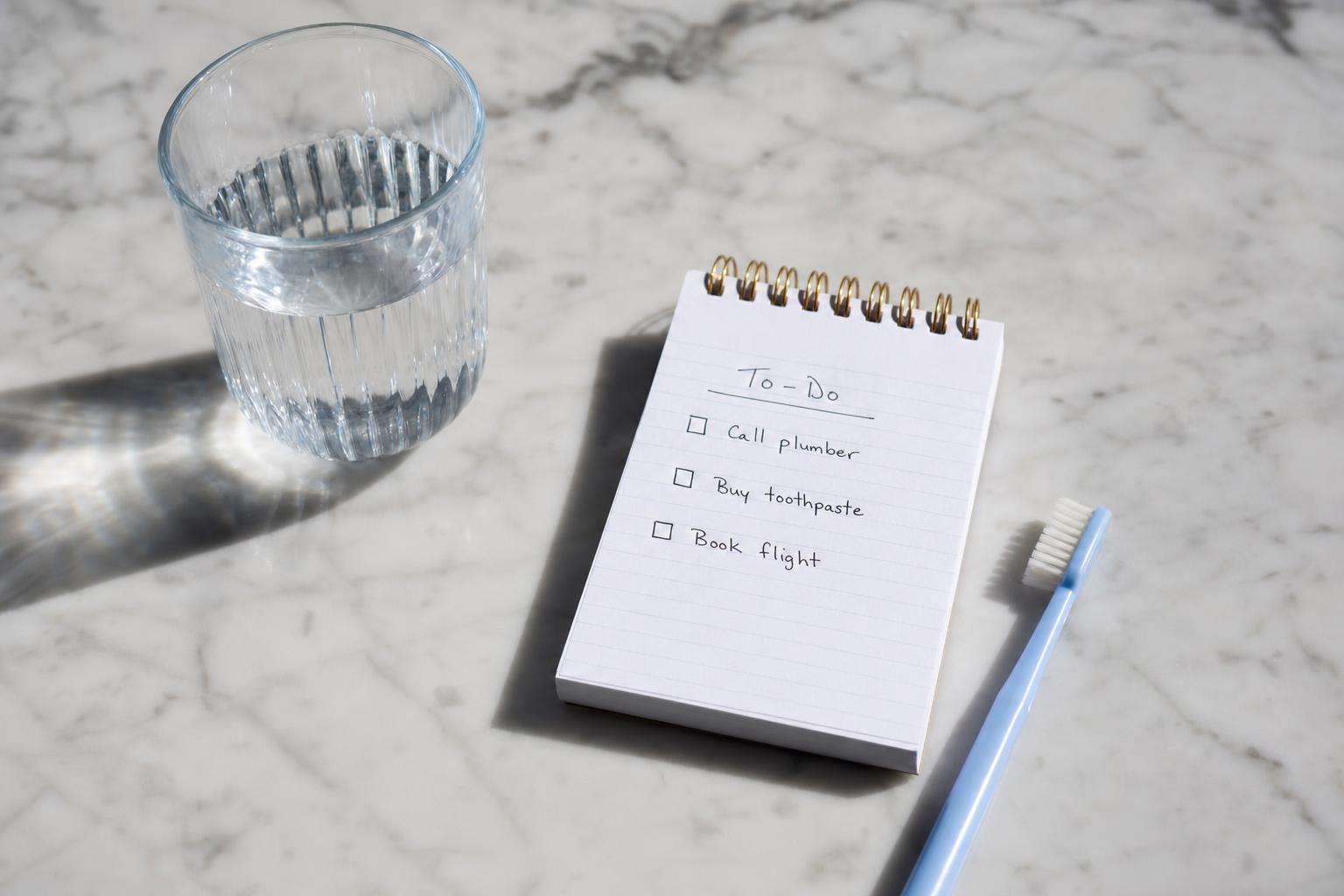 Family kitchen decision notepad with water glass and toothbrush, no people