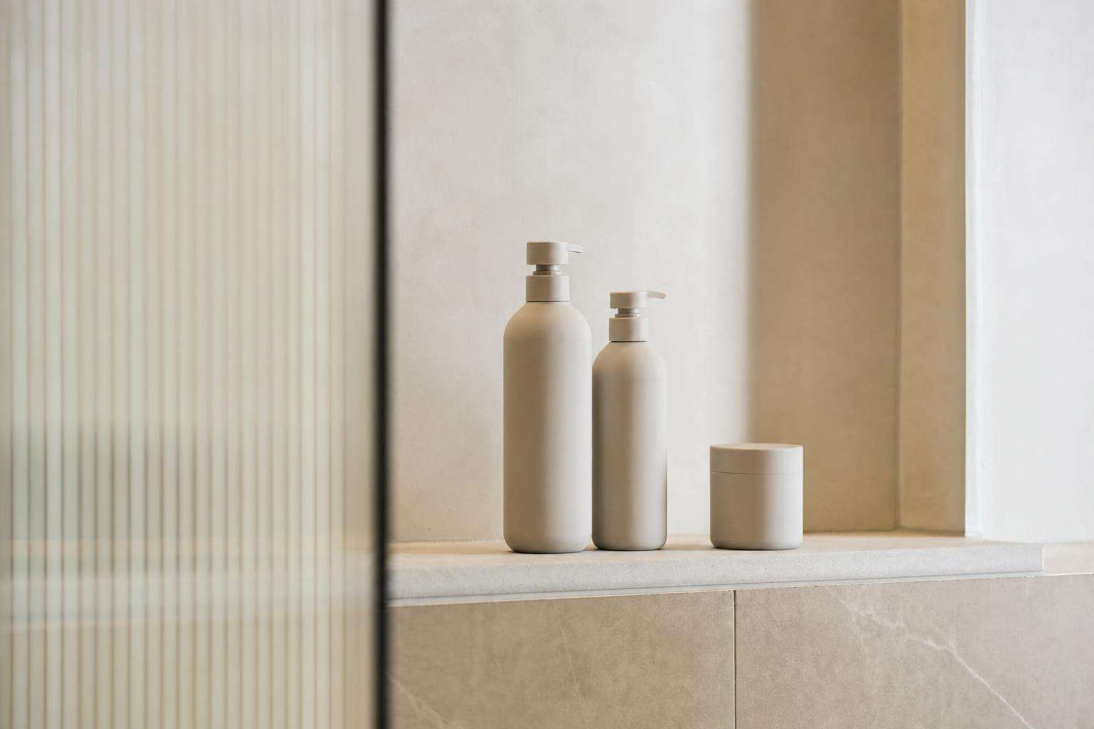 Unscented personal care bottles on a clean bathroom shelf, no people
