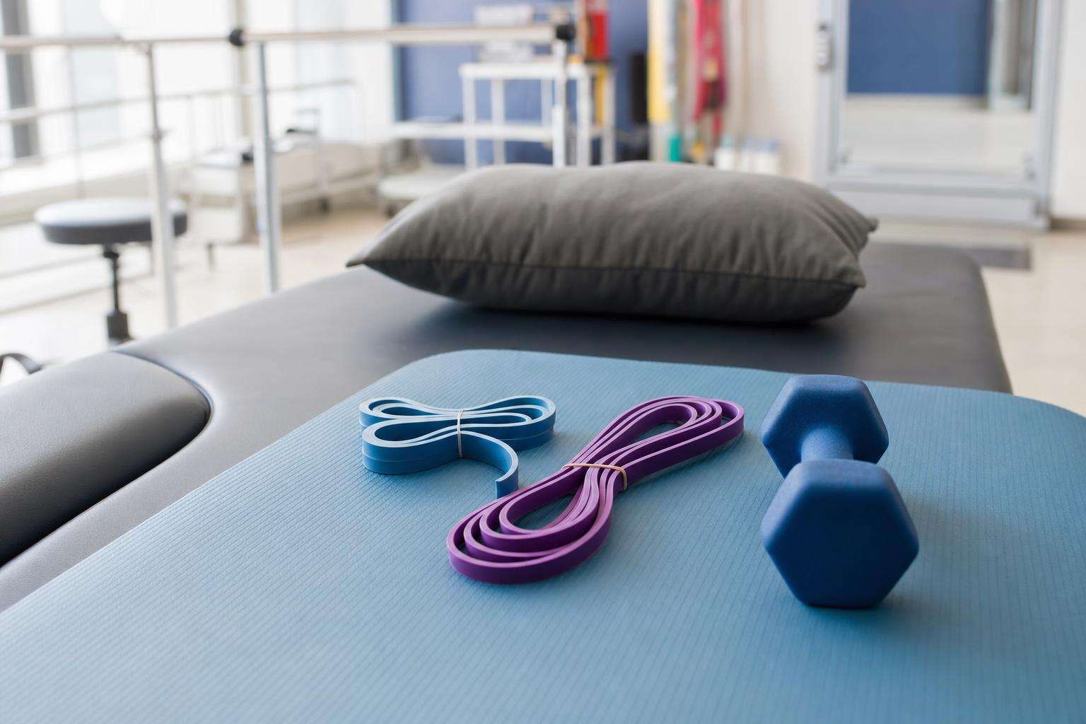 Resistance band and ankle weights for tendon loading on a mat, no people