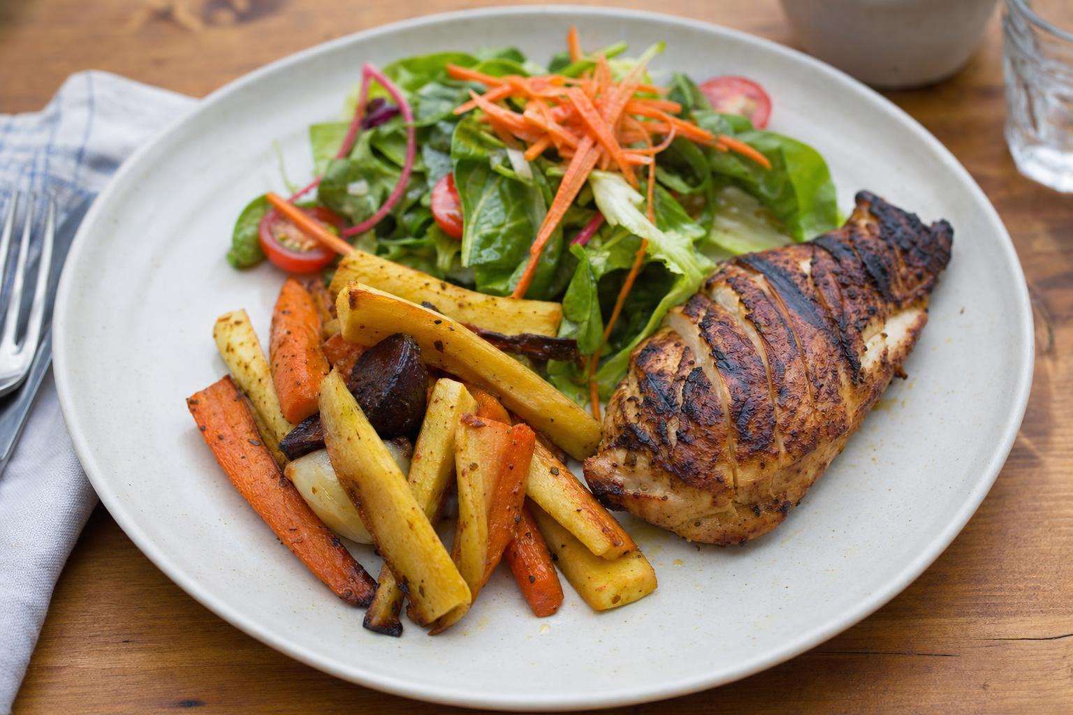 Grilled protein with seasonal vegetables on a plate, no people
