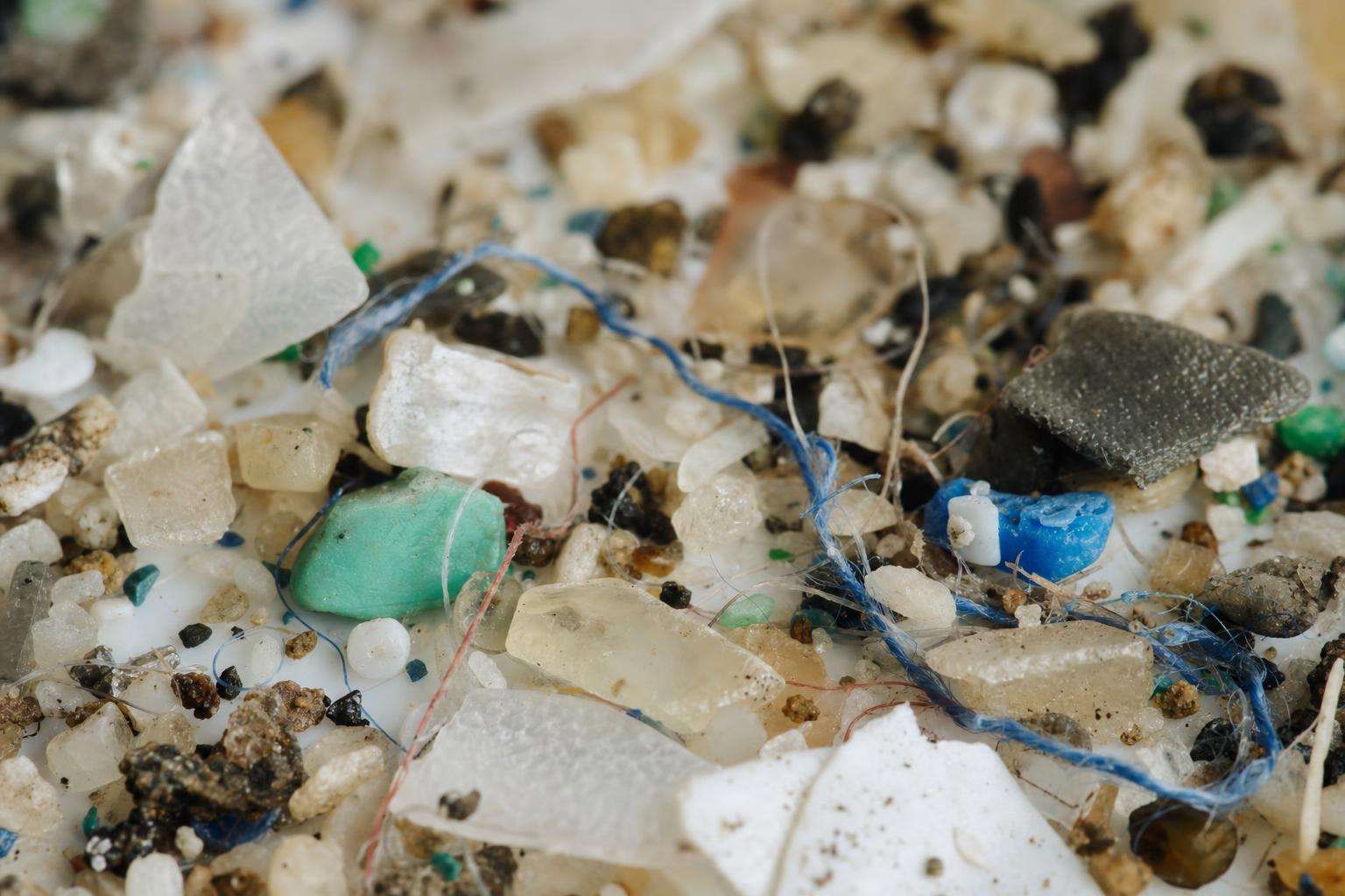 Macro close-up of plastic fragments and fibers on glass, no people