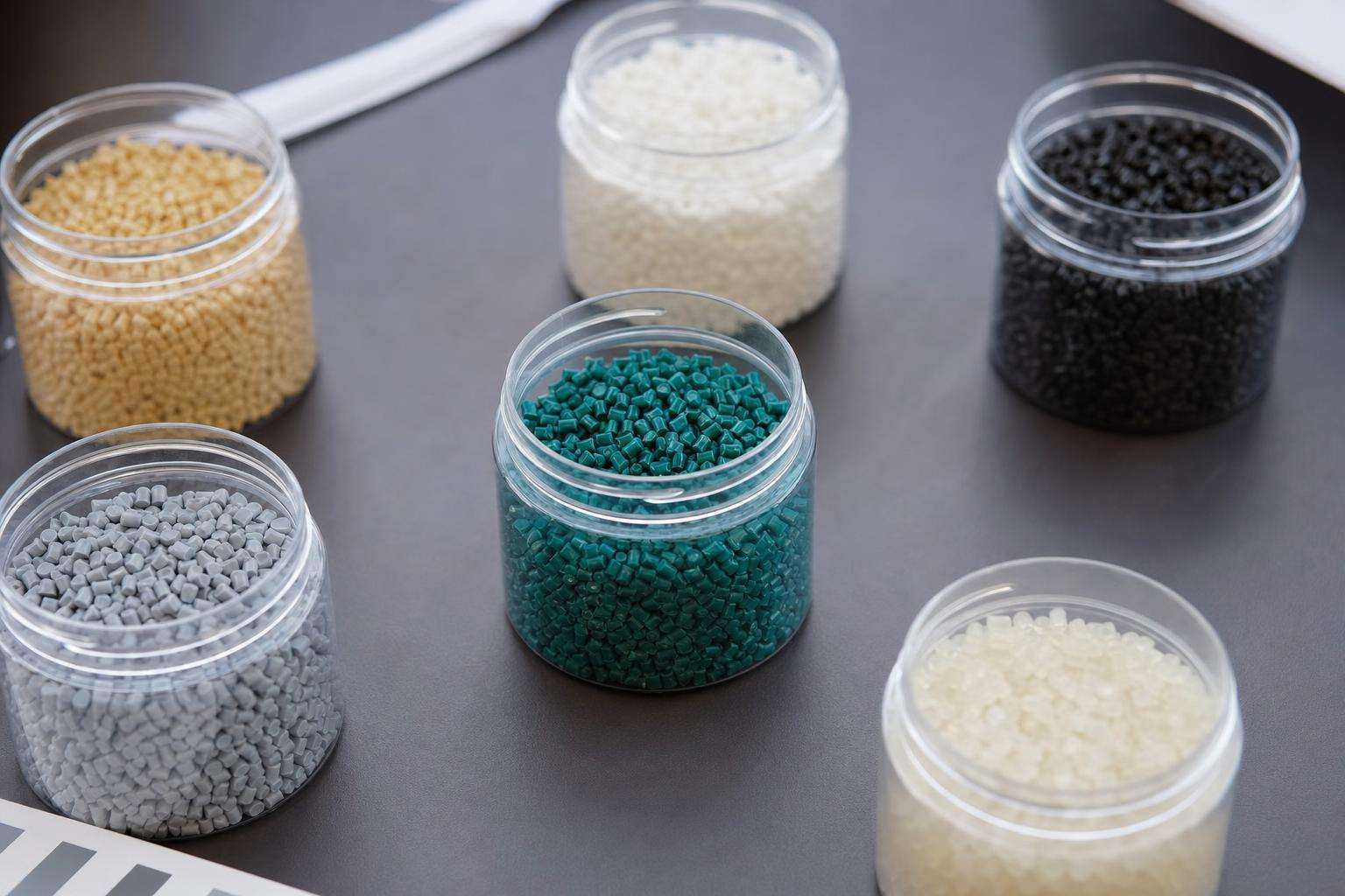 Assorted plastic resin pellets and polymer samples, no people