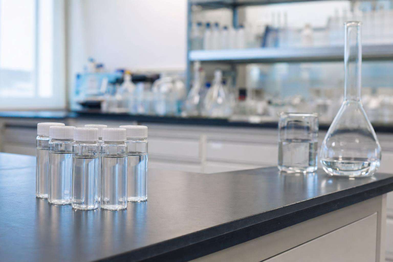 Clean laboratory glassware and water sample vials on a clinical bench, no people