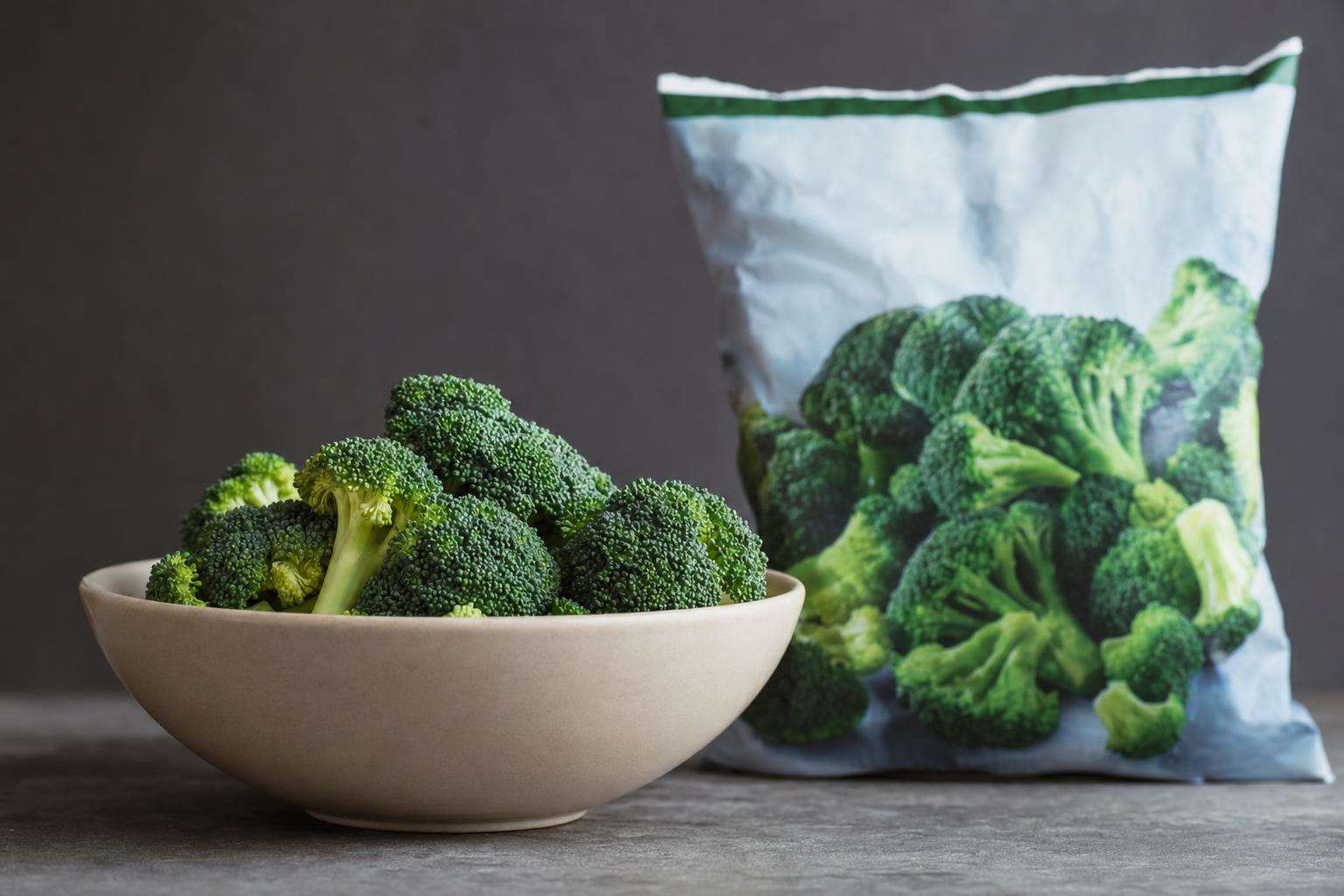 Fresh and frozen vegetables side by side on a kitchen counter, no people