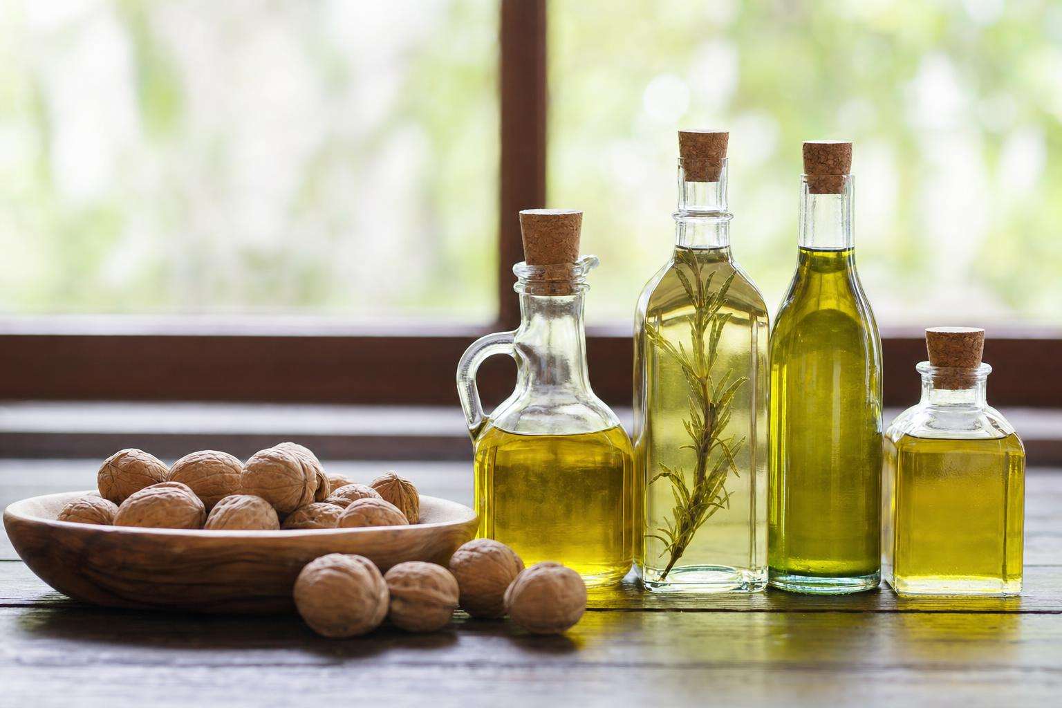 Measuring spoons with various cooking oils and nut bowl, no people