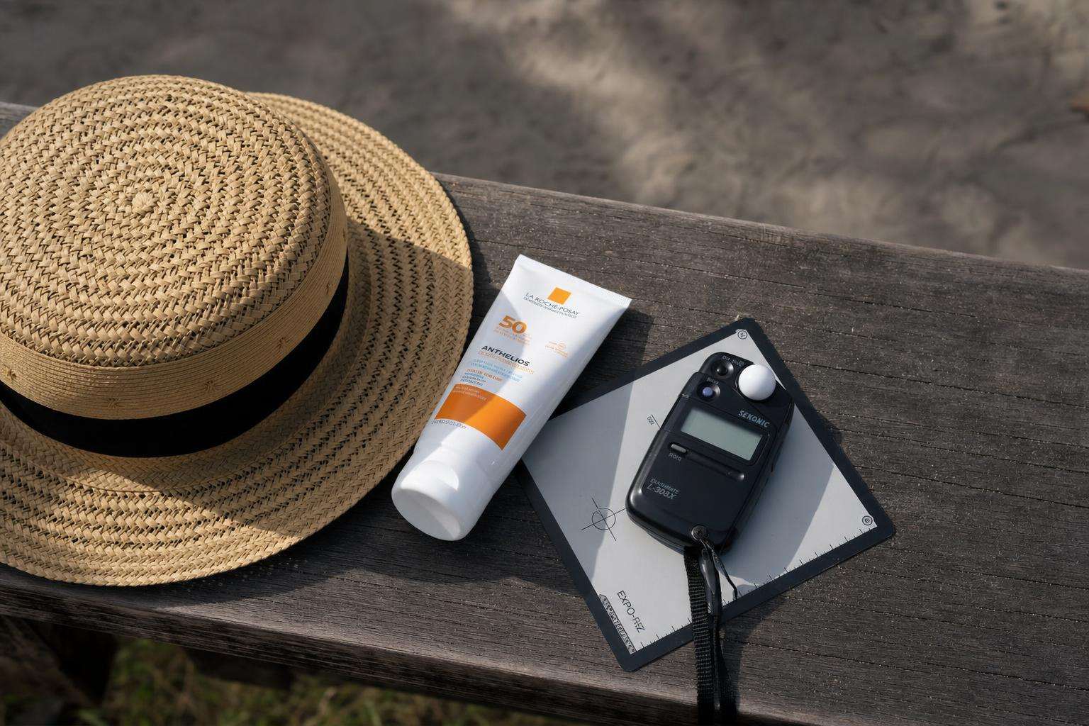 UV index phone widget concept beside sunscreen and hat, no people
