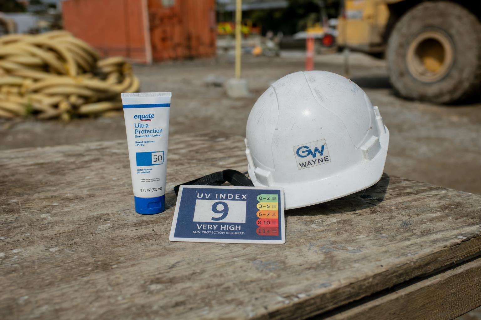 Sunscreen tube and wide-brim work hat for outdoor labor, no people